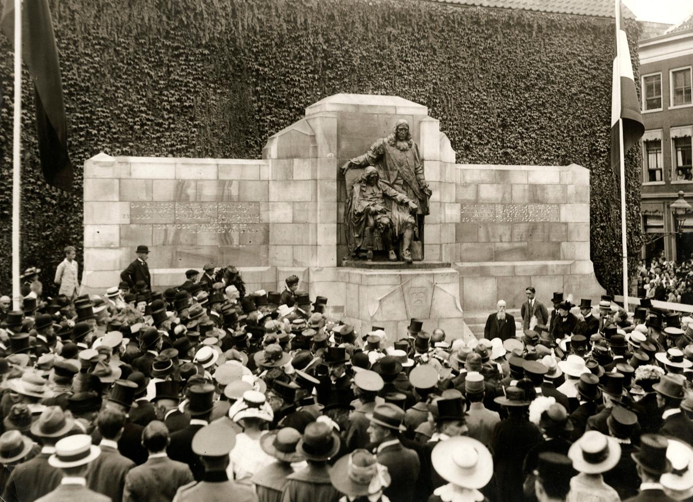 Zwart-witfoto uit 1918: het pas onthulde standbeeld van Johan en Cornelis de Witt, omringd door een menigte met hoeden